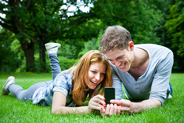 istock Young couple using a smartphone in the park 181086401
