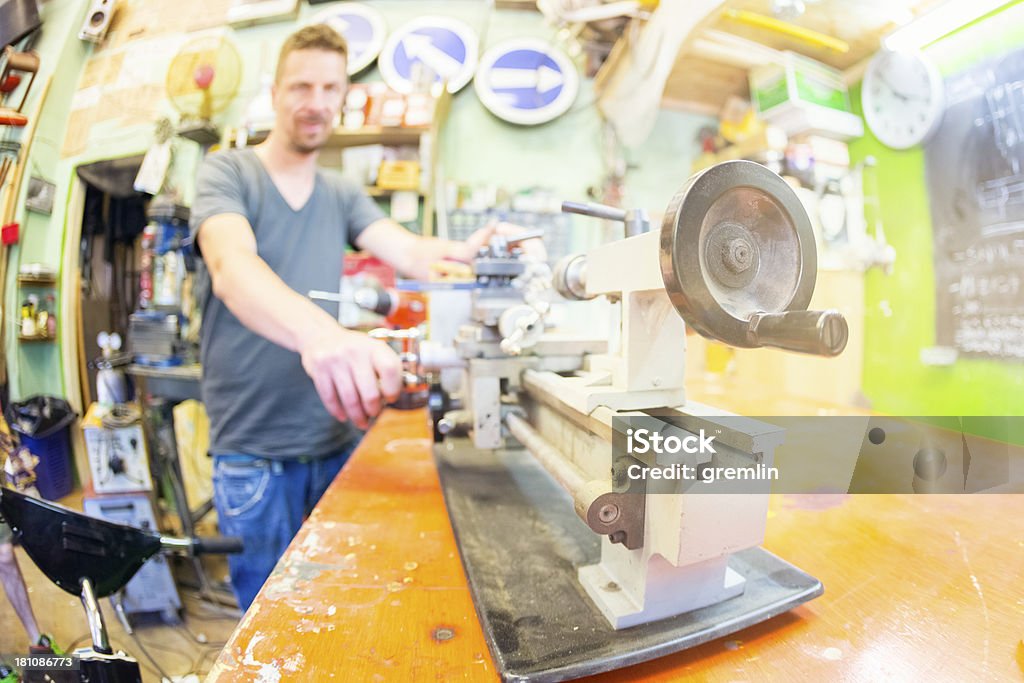 Man in small workshop working with drilling machine Man in small workshop working with drilling machine- Adult Stock Photo