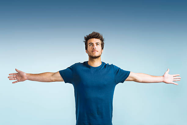 Hope: young man with arms outstretched stock photo