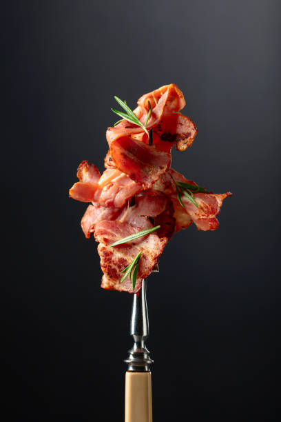 istock Roasted bacon slices with rosemary on a fork. 1810883893