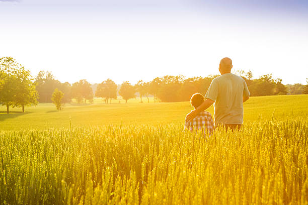 istock Farmer with his son at sunset 181088583