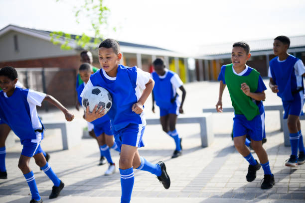 istock Boy holding soccer ball runs to practice with teammates 1810886061