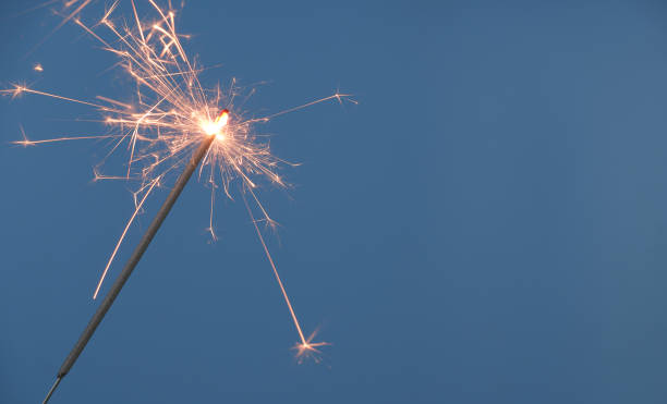 istock Christmas sparkler burning on blue background 1810891057