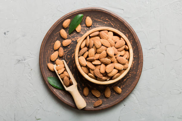 istock Fresh healthy Almond in bowl on colored table background. Top view 1810893865