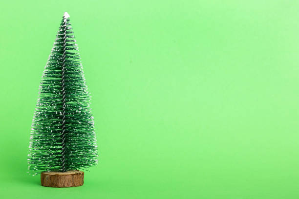 istock One small Christmas tree on colored background. new year decoration with copy space 1810893888