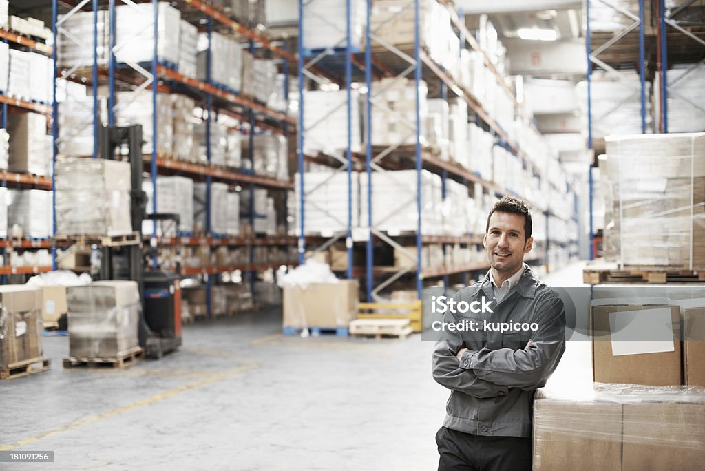 Hombre joven de pie en el almacén - Foto de stock de Sonreír libre de derechos
