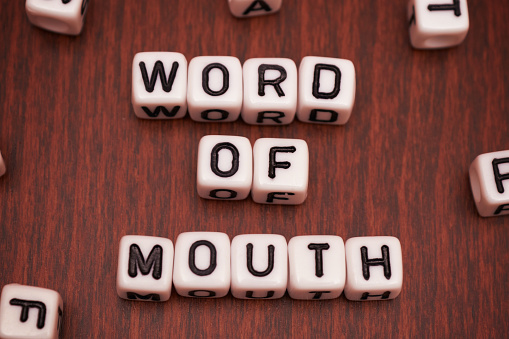 Word Of Mouth Dice Letter on table