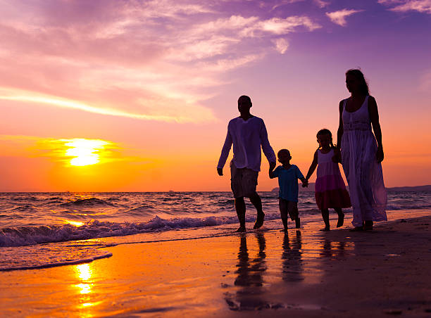 istock Family walking on a beach at sunset 181092531