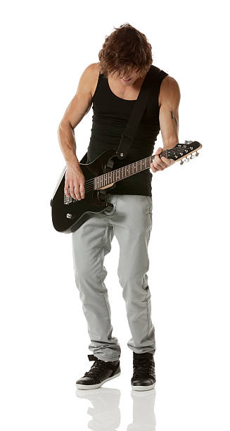 istock Young man playing guitar against white background 181093237