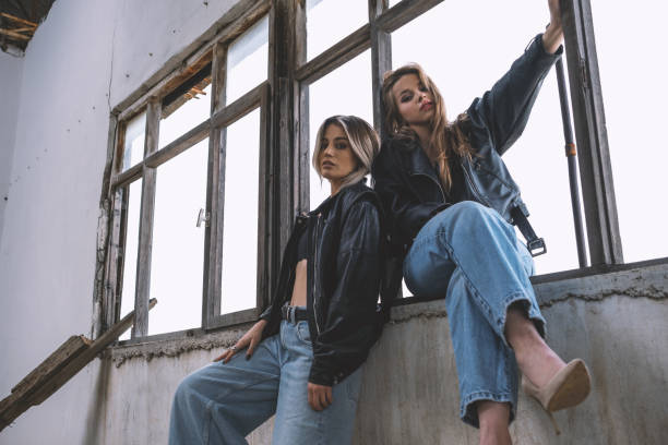 Two young and beautiful blonde women were wearing blue jeans and leather jackets.