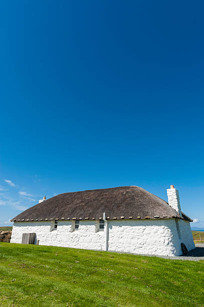 istock Quaint thatched cottage below clear blue summer skies 181094241