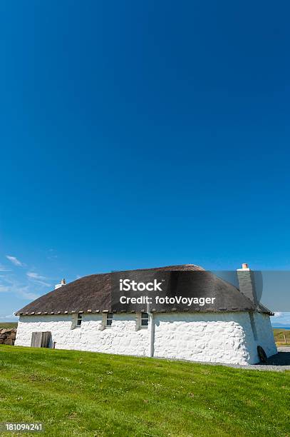 Quaint Thatched Cottage Below Clear Blue Summer Skies Stock Photo - Download Image Now