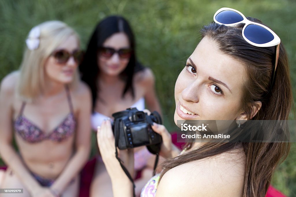 Holiday Snapshot Young woman taking pictures of her friends on picnic. 20-24 Years Stock Photo
