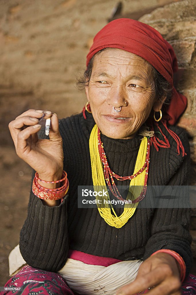 Nepali woman smoking cigarette. Bhaktapur. Bhaktapur is an ancient Newar town in the east corner of the Kathmandu Valley, Nepal. It is the third largest city in Kathmandu valley and was once the capital of Nepal during the great Malla Kingdom until the second half of the 15th century. Bhaktapur is listed as a World Heritage by UNESCO for its rich culture, temples, and wood, metal and stone artwork.http://bem.2be.pl/IS/nepal_380.jpg Nepal Stock Photo