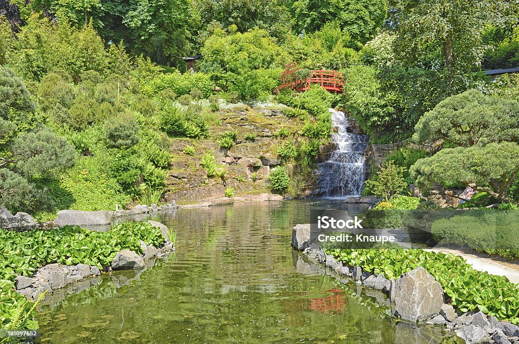 Ponte pedonal de vermelho com cascata e Lago no Jardim Japonês - Royalty-free Ajardinado Foto de stock