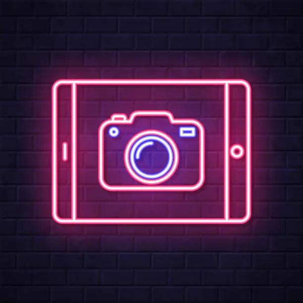Vector illustration of Tablet PC with camera. Glowing neon icon on brick wall background