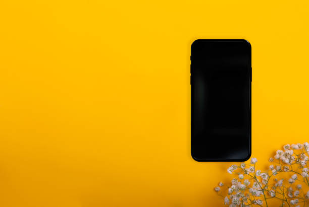 istock phone on a yellow background and wireless headphones 1810986863