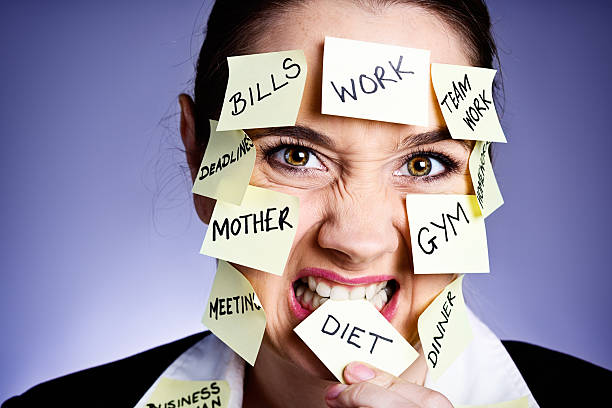 istock Overworked woman covered in  task reminders bites one angrily 181099956