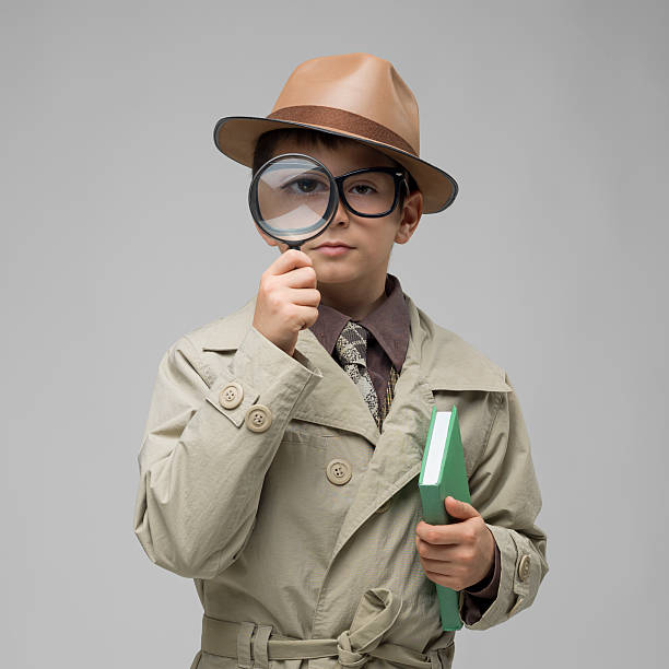 istock Little dedective looking through magnifying glass on gray background 181100173