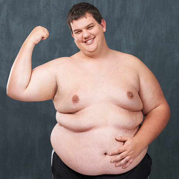 Flaunting his flab! An obese young man without a shirt flexing for the camera fat guy no shirt stock pictures, royalty-free photos & images