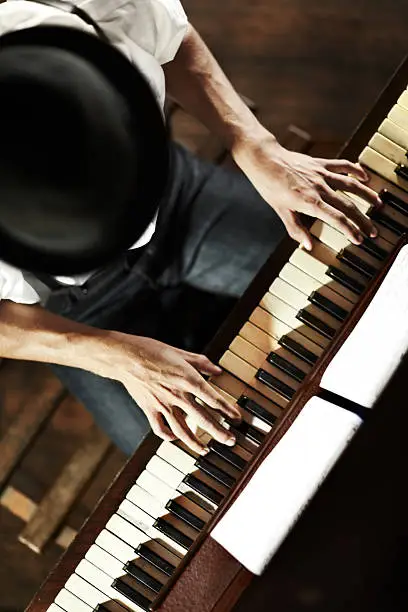 High-angle view of a young musician playing the piano