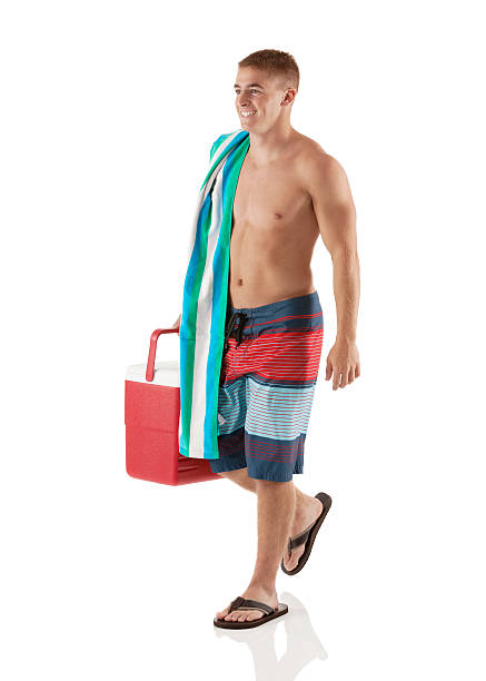 istock Smiling shirtless man walking with an ice box 181101564