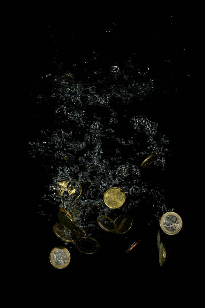 istock Vertical shot of Euro coins falling into water 1811029085