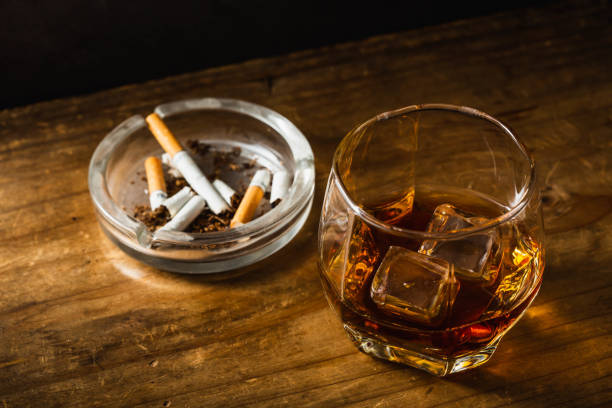 istock Whiskey with ashtray and cigarettes on wooden table 1811029107