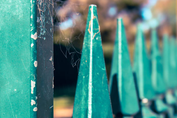 close up of old green iron picket fence