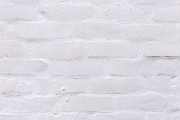 Fragment of the old many times whitewashed brick outer wall of a building close-up, facade fragment, background