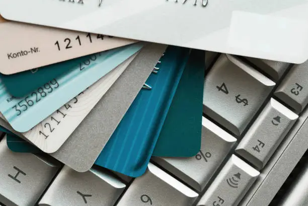 Close-up of multiple credit cards stacked on a laptop keyboard, emphasizing online payment and financial security