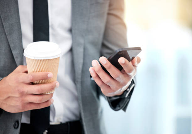 istock Businessman, coffee and smartphone with hands for communication on client feedback and lunch break with technology. Professional, person and email on phone with read text, social media and networking 1811112303