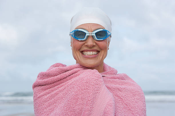 femme à la plage, enveloppé dans une serviette de bain - bonnet de bain photos et images de collection