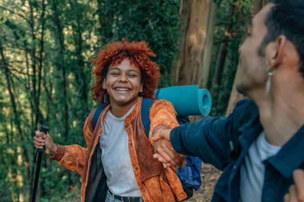 istock young people holding hands helping each other hiking 1811130959