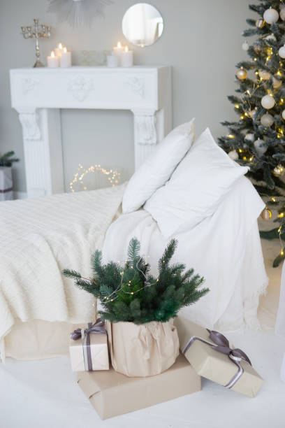 istock Bright interior with a false fireplace decorated for Christmas. Christmas trees with garlands, balloons and lights. 1811138056