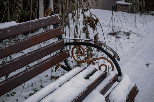 Kyiv, Ukraine. November 23, 2023: A snowy bench stands near the house