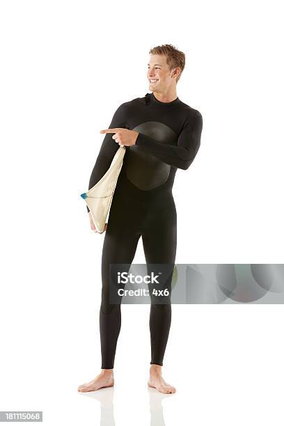 Male Surfer With A Surfboard Pointing Sideways Stock Photo - Download Image Now - 18-19 Years, Adult, Adults Only