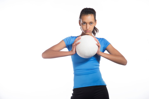 Focused teenager holding a volleyball.