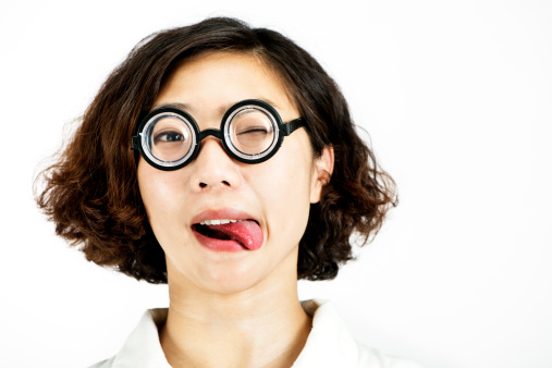 Young Chinese woman wearing funny glasses poking her tongue out.
