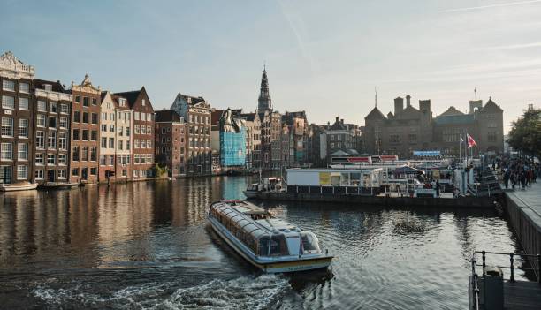 석양이 비추는 암스테르담의 도시 풍경으로 둘러싸인 고요한 수역 - amsterdam skyline harbor night 뉴스 사진 이미지