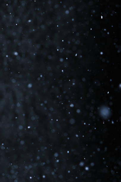 istock Bokeh of white snow on a black background. Snowfall - design element. 1811161907