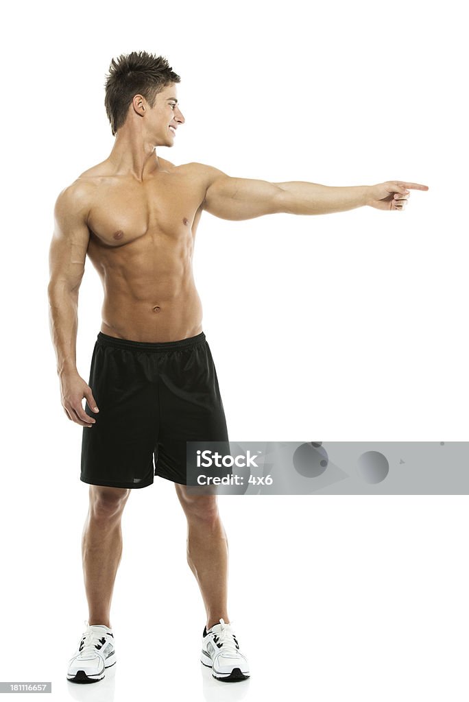 Przystojny mężczyzna, wskazując na bok, bez koszulki - Zbiór zdjęć royalty-free (20-29 lat)