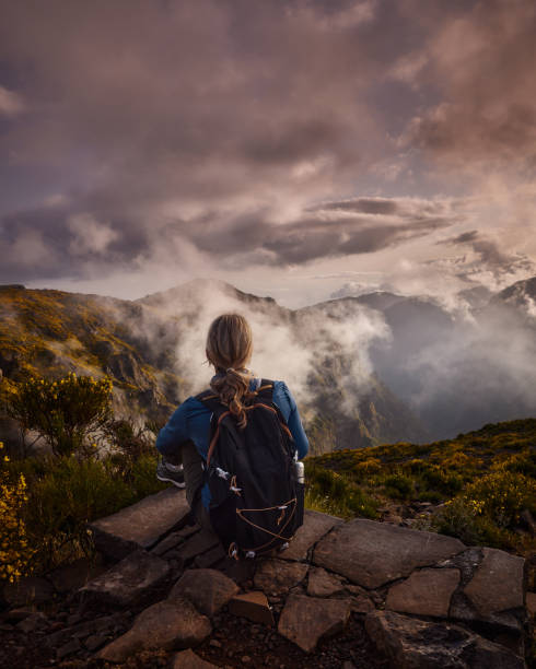 istock Rear view of a female backpacker resting on a mountain. 1811167867
