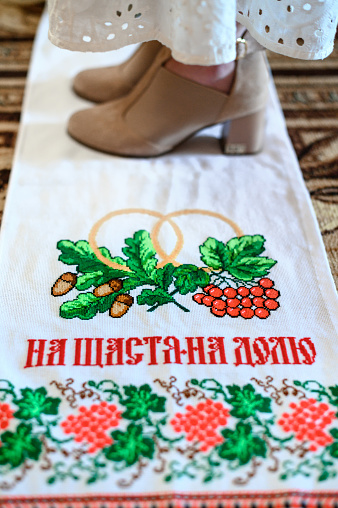 A wedding embroidered towel at a Ukrainian wedding, the bride is standing on the towel, legs close-up