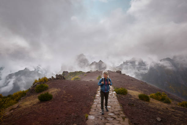 Smiling female hiker walking on a mountain at Pico Ruivo. Copy space.