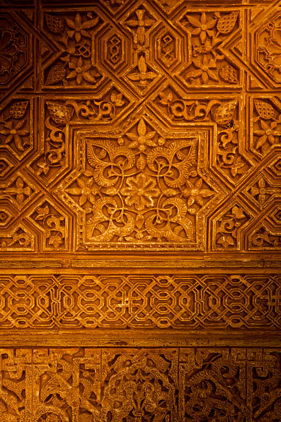 Detail of a wall with tilework and carvings with Arabic script in the Nasrid Palace,Alhambra,Granada,Spain.