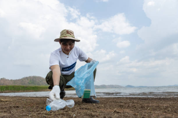 istock Male volunteers collecting garbage, conducting environmental cooperation, saving world reducing global warming, Volunteers clean plastic bag waste in natural attractions. 1811185147