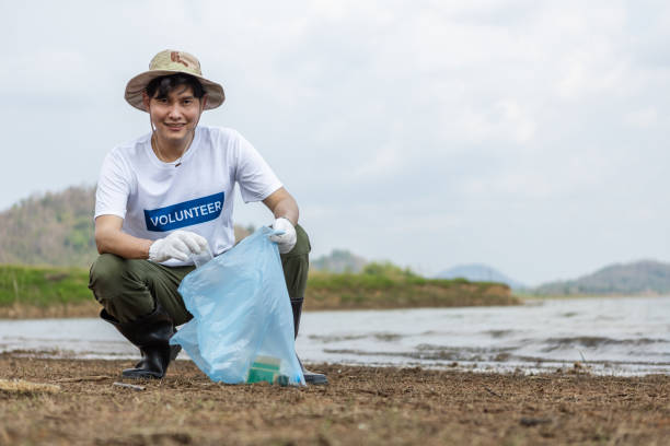 istock Male volunteers collecting garbage, conducting environmental cooperation, saving world reducing global warming, Volunteers clean plastic bag waste in natural attractions. 1811185165