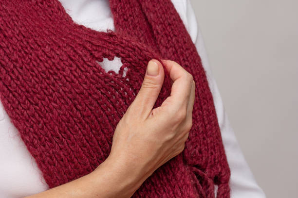 istock Woman hand holding knitted thing with hole made by moth 1811186295