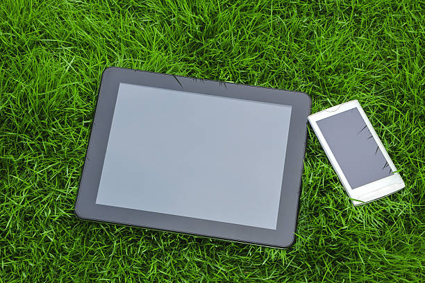 digital tablet and smart phone on green grass
